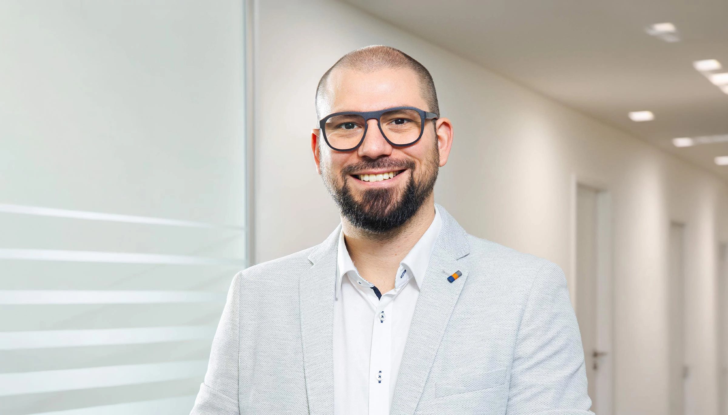 Bereichsleiter Qualität steht professionell im Büro